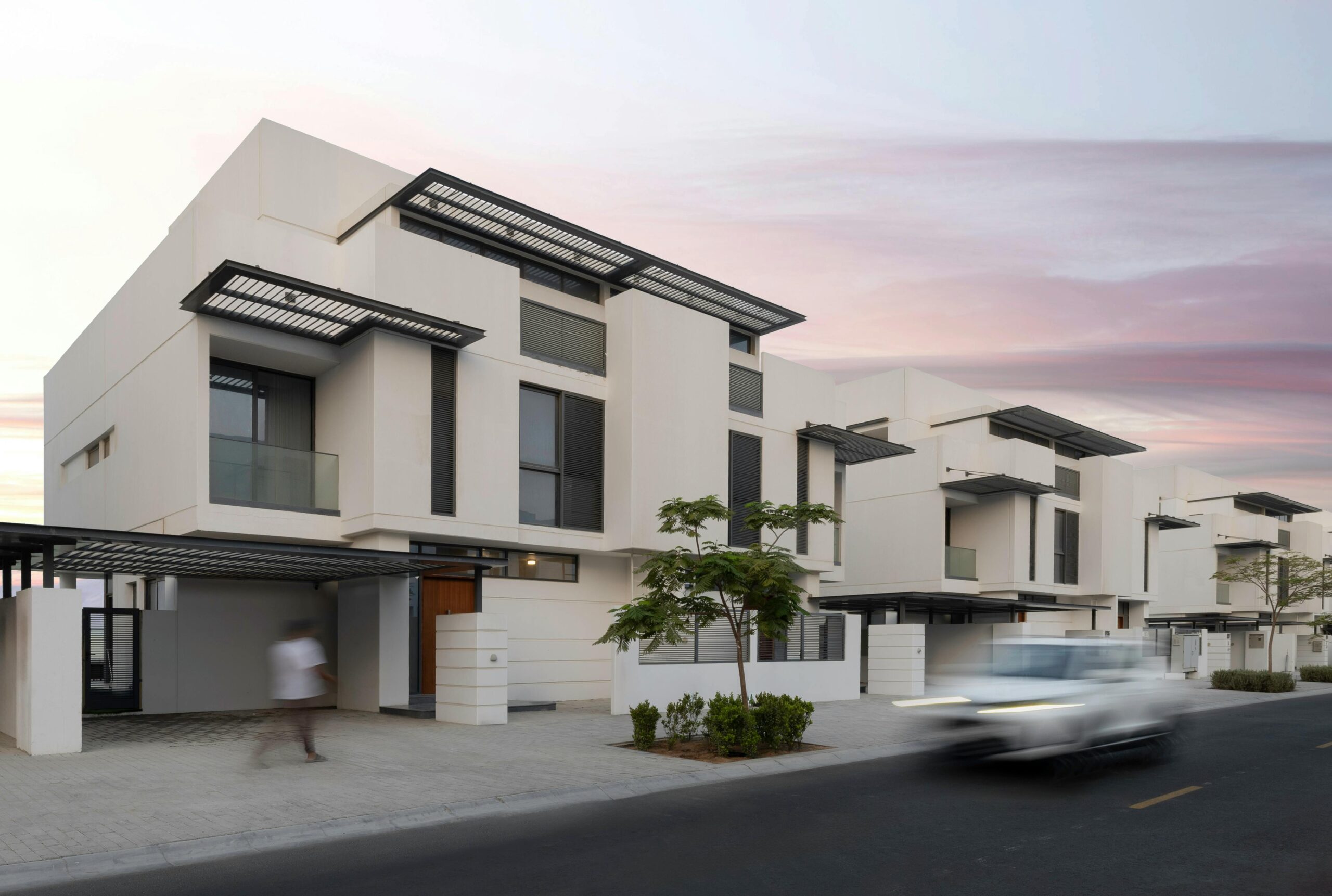 Contemporary white villas at sunset in Sharjah showcasing modern architecture.